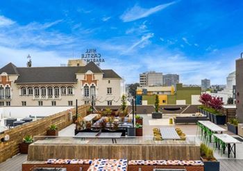 a rooftop terrace with a restaurant and a city in the background